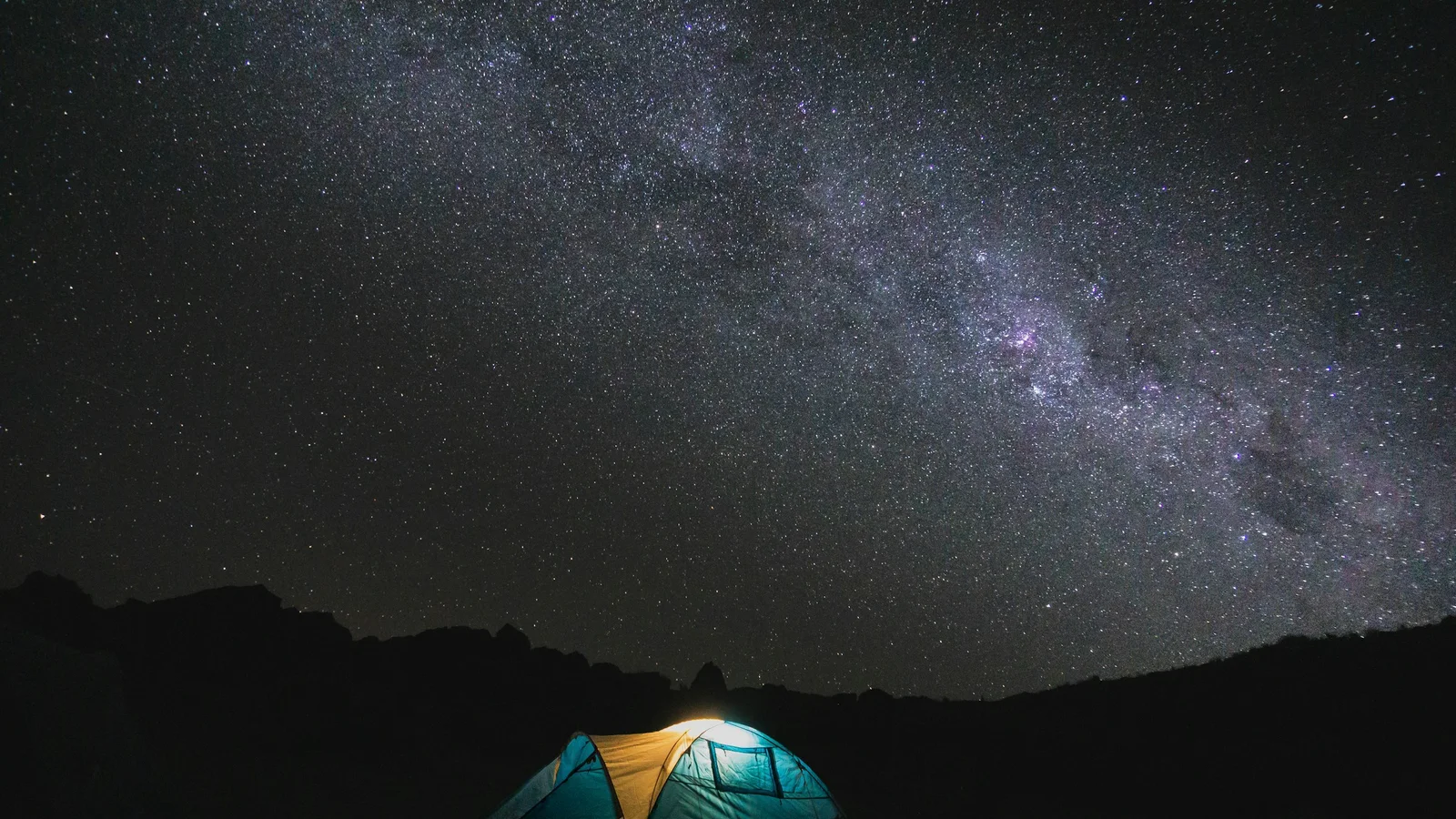 Camping app open on a phone beside a New Zealand campsite
