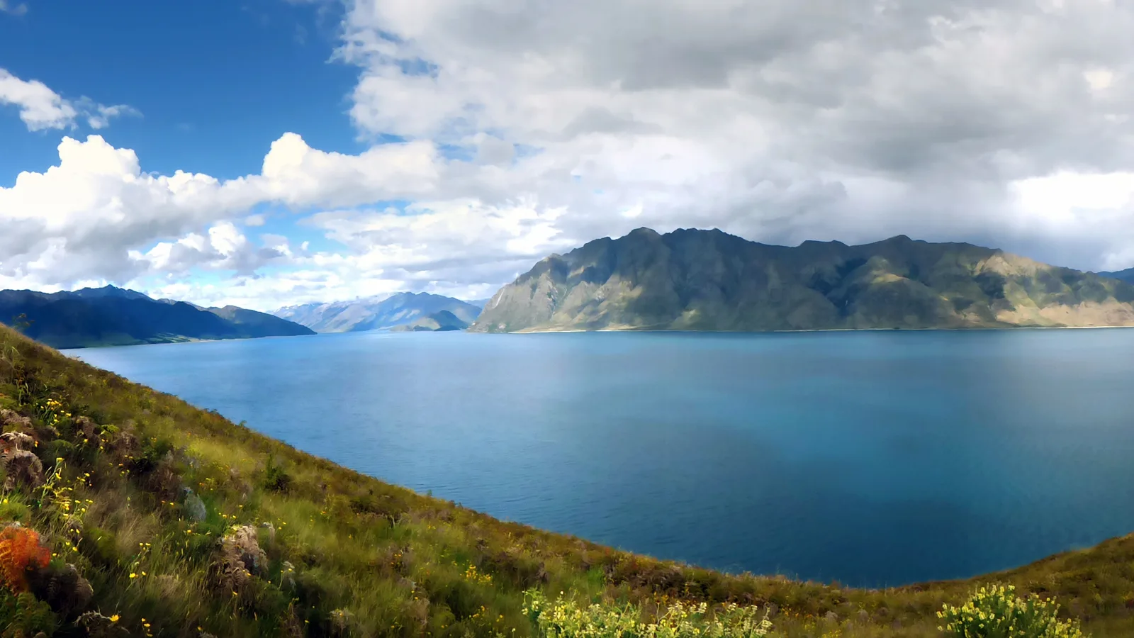 Campervan on a New Zealand highway between mountains and lake